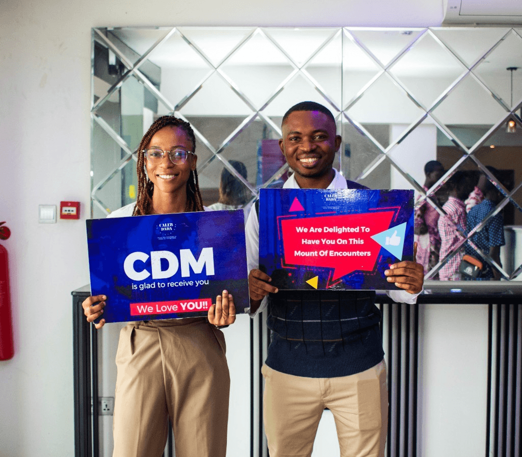 CDM greeters welcoming visitors with signs